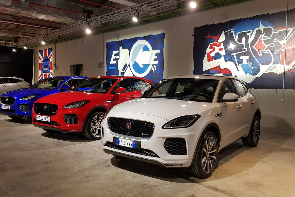 Row of Jaguar E-PACE cars parked in front of the branded venue artwork wall